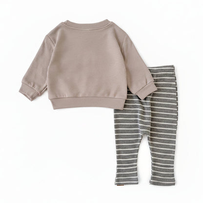 Back view of the gender-neutral baby 2-piece outfit showing the plain beige long-sleeve top and grey striped pants laid flat.