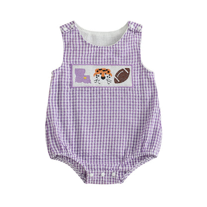 Front view of a purple and white seersucker gingham baby bubble romper featuring a hand-smocked chest plate with a purple Louisiana state map, a friendly orange tiger face, and a football on a solid white background.