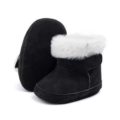 Pair of black unisex baby soft sole crib boots with plush white lining on a white background.