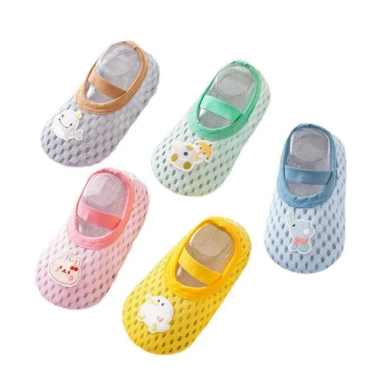 A group of unisex baby and toddler water shoes in various colors including mint green, yellow, pink, and blue, featuring whimsical teapot and animal patches with non-slip rubber soles.