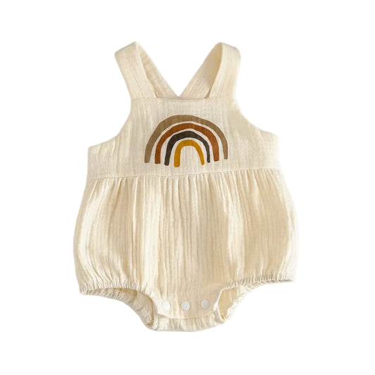 Flat lay of a unisex oatmeal-colored baby romper with a boho brown rainbow print, made of soft crinkle viscose muslin, styled on a white background.
