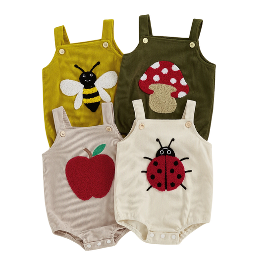 Four baby rompers with insect and fruit and mushroom designs on a white background