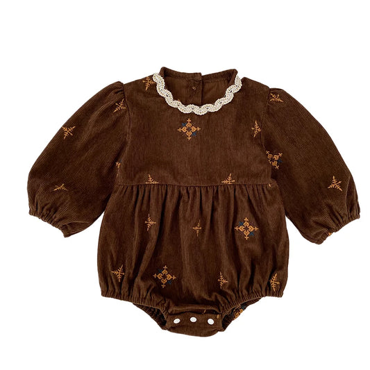 Flat lay front view of a vintage brown corduroy baby girl bubble romper featuring a white scalloped lace collar and floral embroidery.