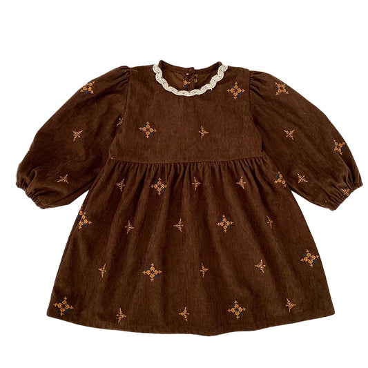 Flat lay front view of a vintage brown corduroy toddler girls dress featuring a white scalloped lace collar, gathered skirt, and geometric floral embroidery.