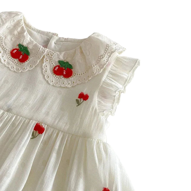 Close-up of the cherry embroidered lace Peter Pan collar on an antique cream baby girl dress.