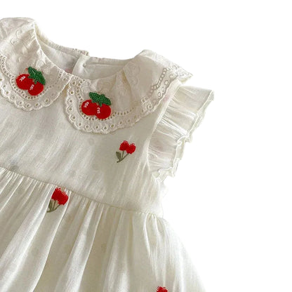 Close-up of the cherry embroidered lace Peter Pan collar on an antique cream baby girl dress.