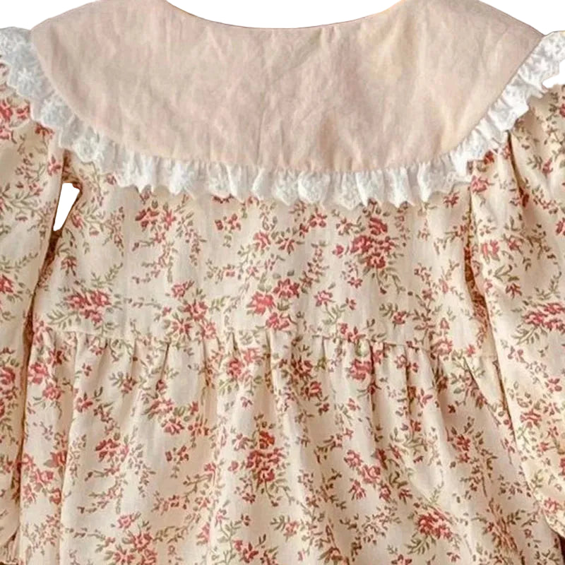 Detailed back view of the delicate white lace trim on the contrast collar of the cream vintage floral baby romper.