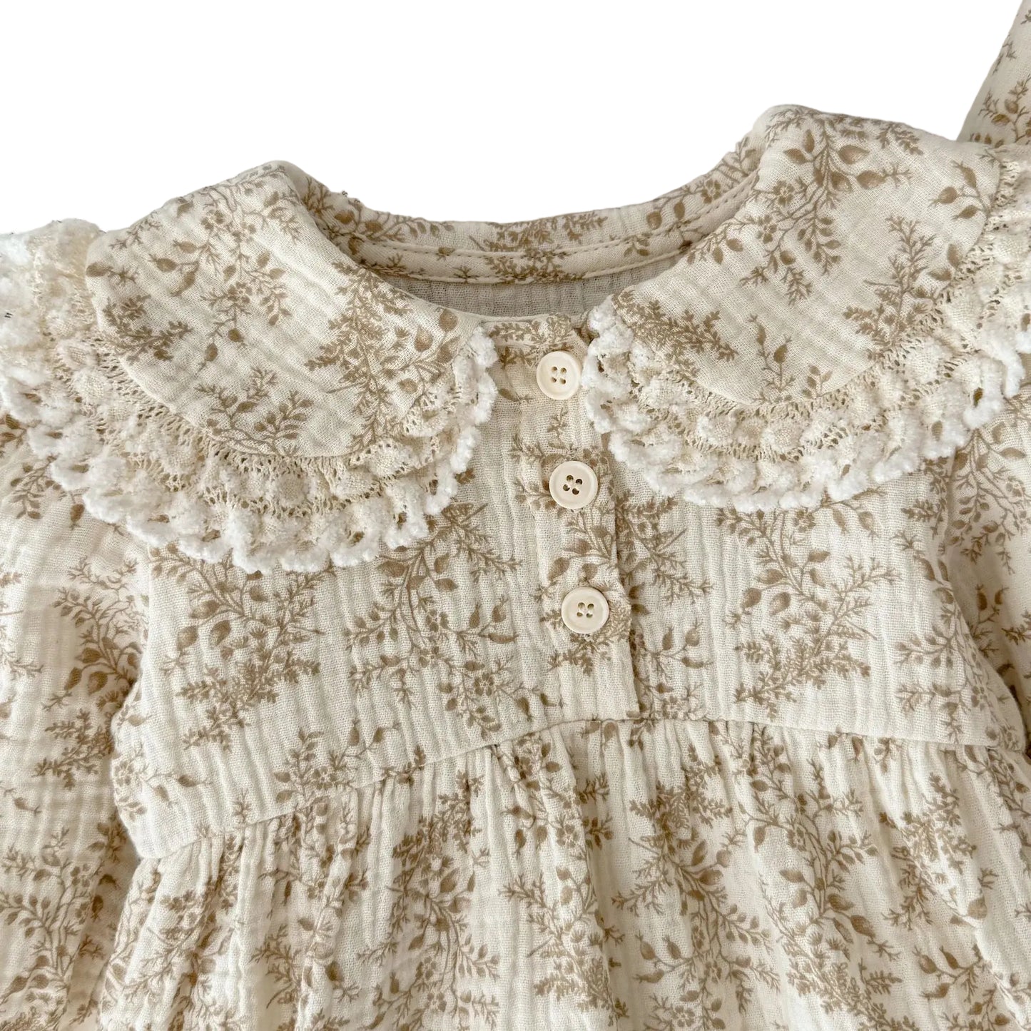 Close-up detail of lace-trimmed Peter Pan collar and front buttons on a vintage floral long sleeve baby outfit.