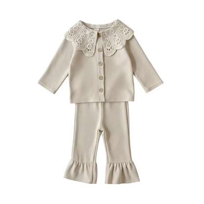 A two-piece baby girl's boutique clothing set in cream ribbed knit, featuring a long-sleeve cardigan with a large vintage-style white lace scalloped collar and matching flare-bottom leggings with ruffle cuffs, displayed on a clean white background.
