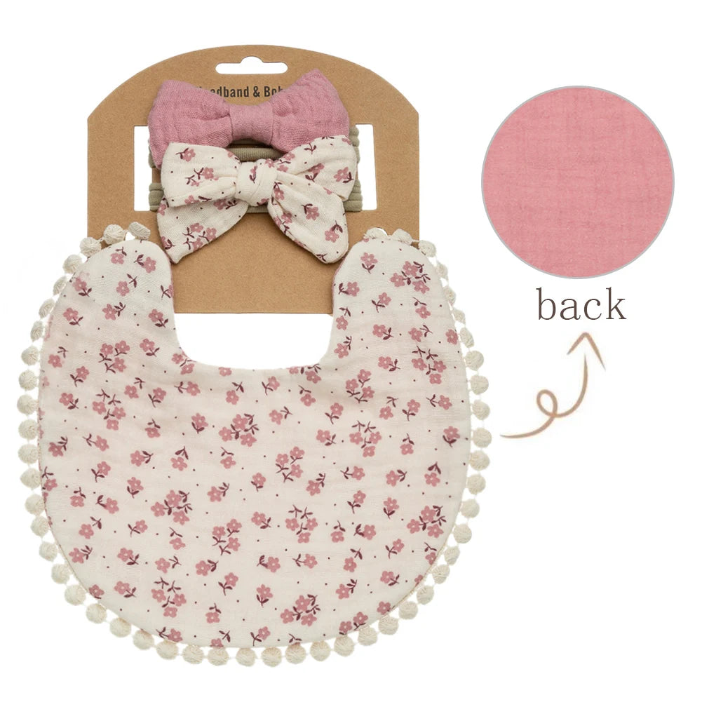 Vintage rose floral pattern muslin baby girl bib with dusty pink reversible backing and matching bows.