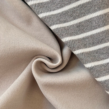 Close-up showing the soft, folded fabric texture of both the solid beige material and the grey and white striped material.