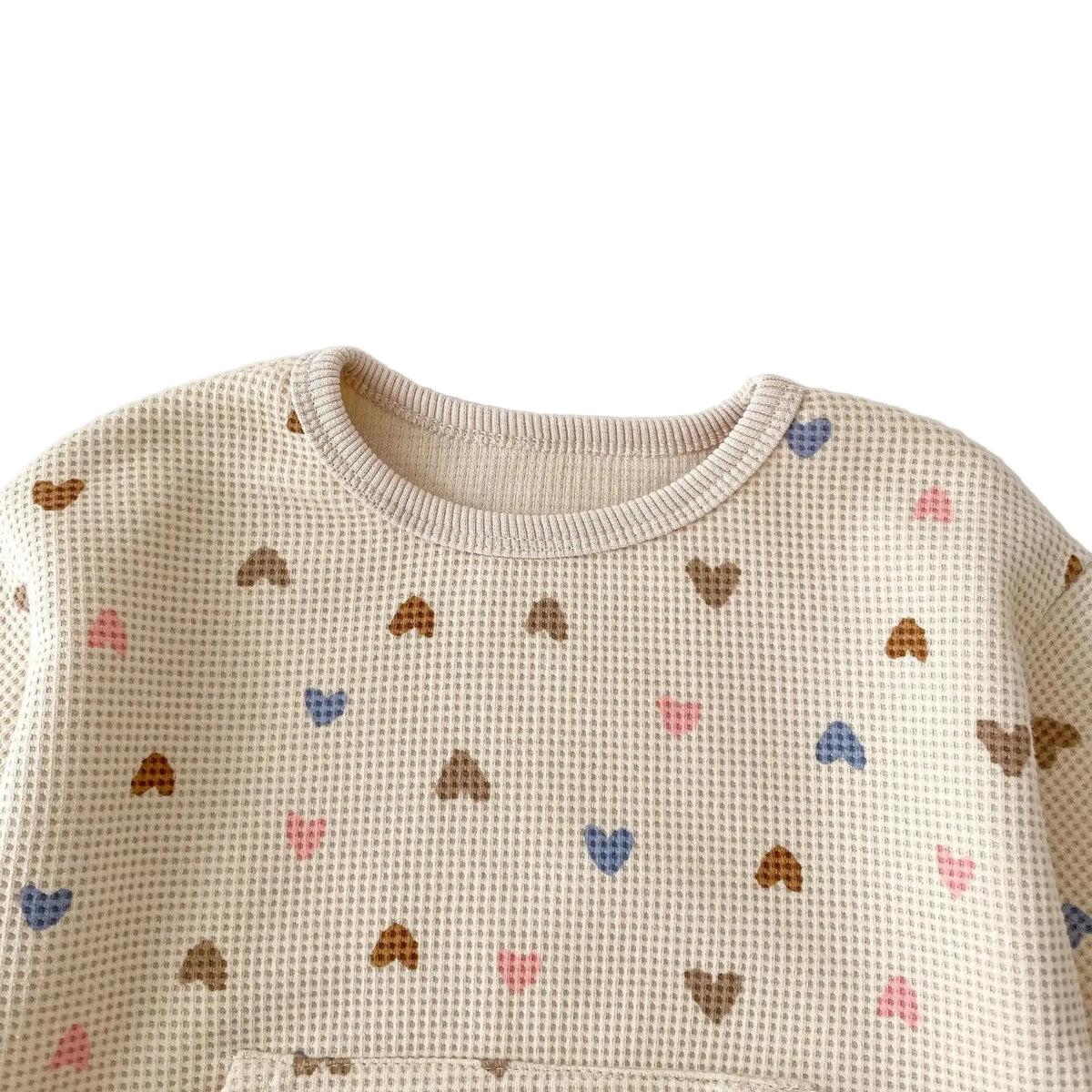 Close-up detail of the crewneck collar and textured waffle fabric on the heart print sweatshirt