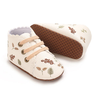 Soft anti-slip sole on white embroidered baby girl booties.