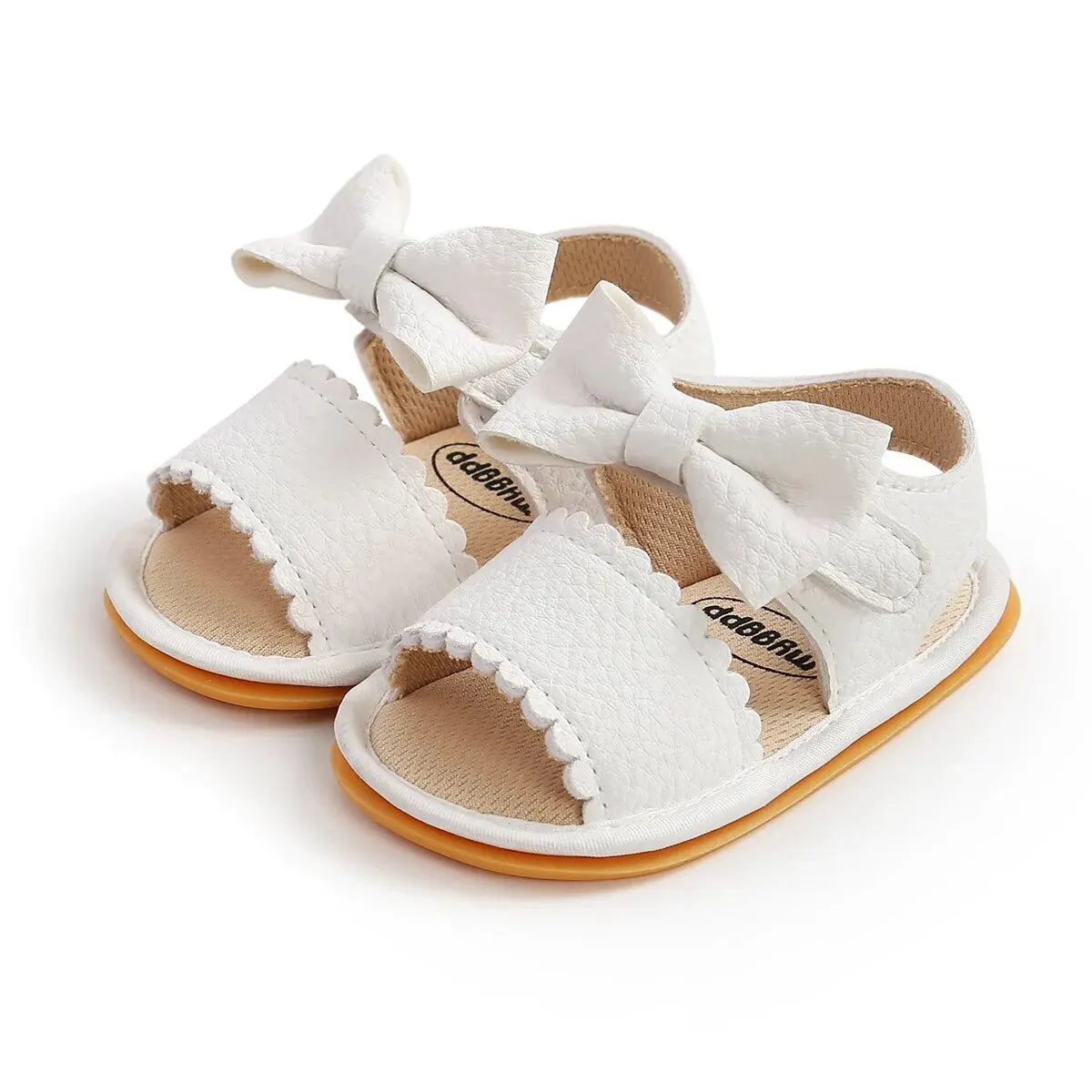 Side angle profile of a single white leather baby girl sandal displaying the soft upper material and flat flexible rubber outsole.