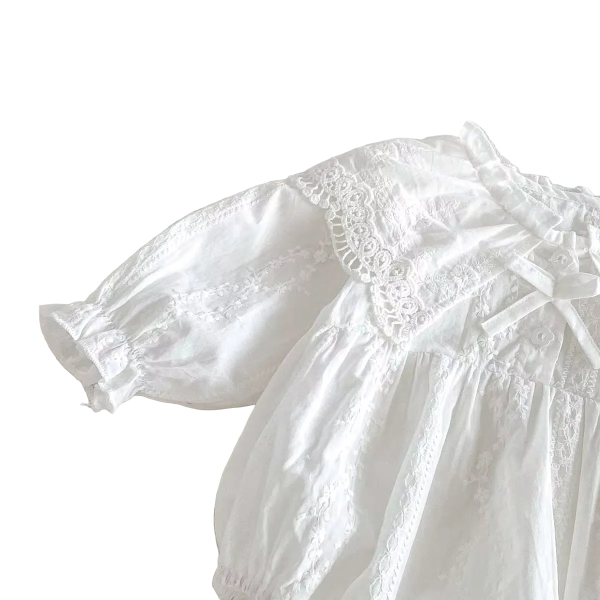 Angled view highlighting the lace shoulder trim and gathered long bishop sleeve on a white baby romper.