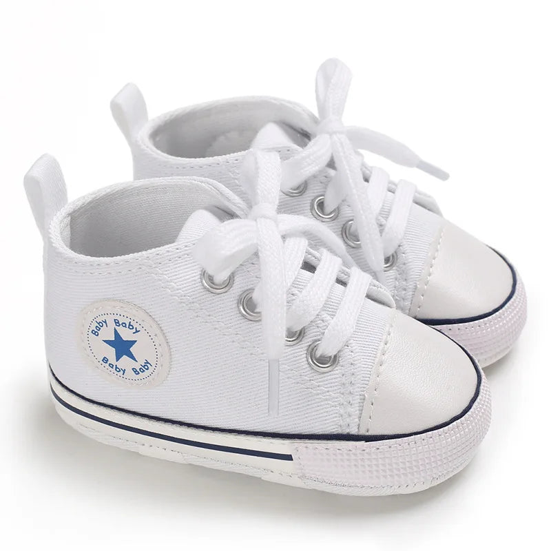 Crisp white classic canvas infant sneakers with flexible non-slip fabric outsole.