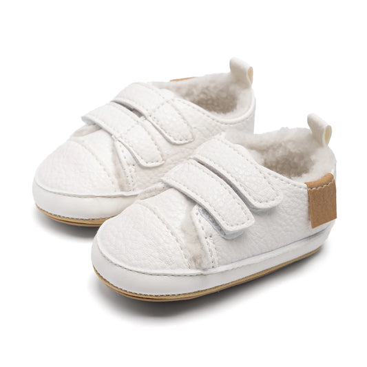 Pair of white fleece-lined infant winter sneakers with double adjustable straps and soft tan soles.