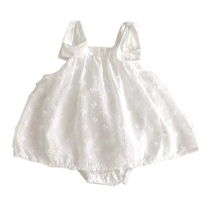 Flat lay of the cloud white floral Swiss dot baby girl princess romper dress on a plain background.