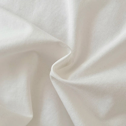 Extreme close-up of the soft, ribbed white knitted cotton-polyester blend fabric used for the baby bodysuit.