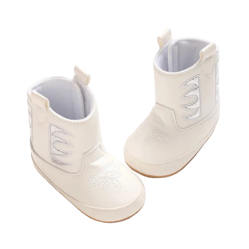 Two white and silver baby cowgirl boots displayed at a top angle, highlighting the premium PU leather upper and wide opening.
