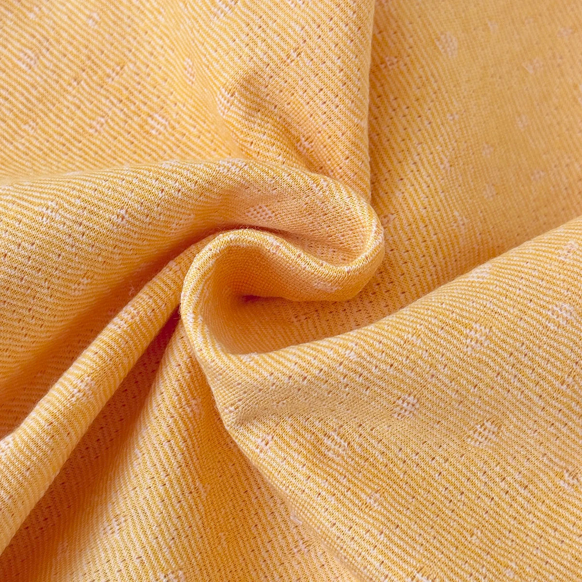 Close-up of the soft, textured yellow interior fabric of the baby girl bubble romper.