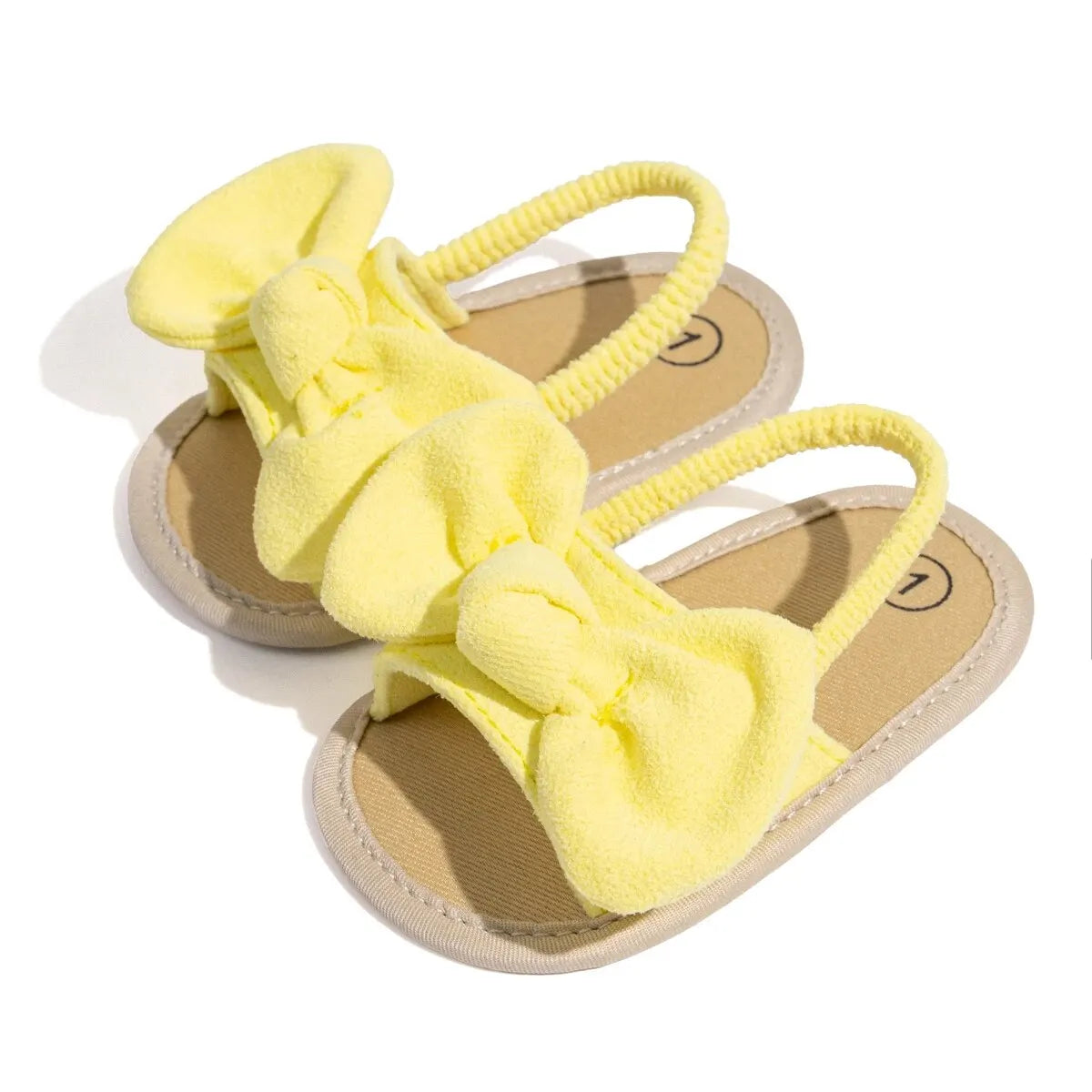 Angled view of bright yellow baby girl soft sole summer sandals.