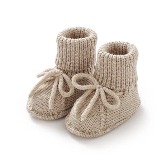 Handmade knit baby booties with high ribbed ankle cuff and yarn tie, anti-slip soft sole for infants 0-12 months.