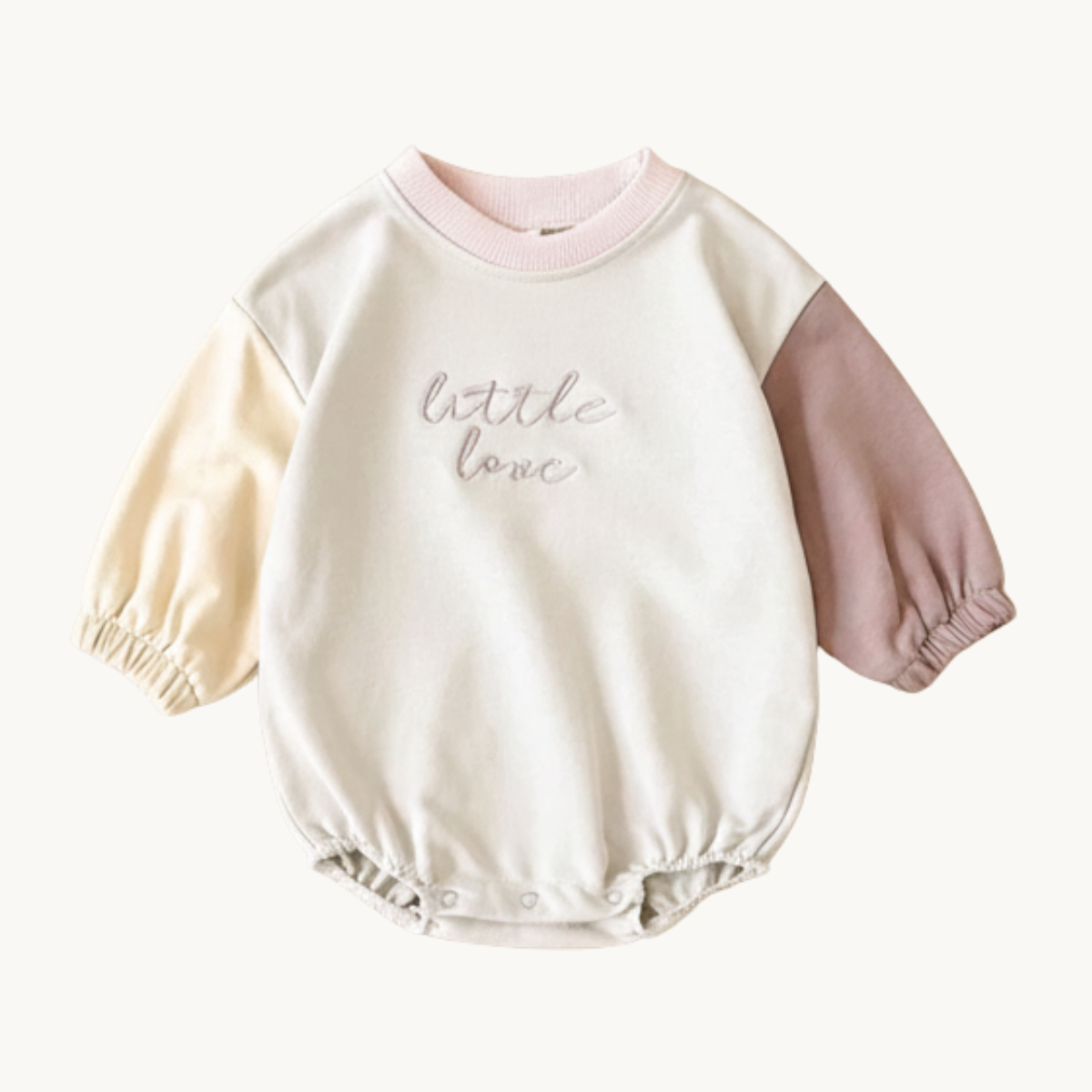 Mauve and buttercream yellow baby girl bubble romper with "little love" embroidery on a neutral beige background.