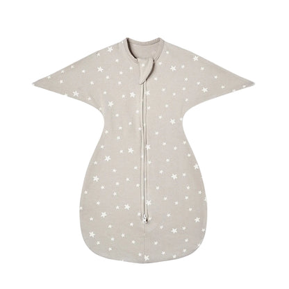 Neutral beige cotton baby sleep sack with white star pattern, featuring an arms-up swaddle transition design and two-way zipper