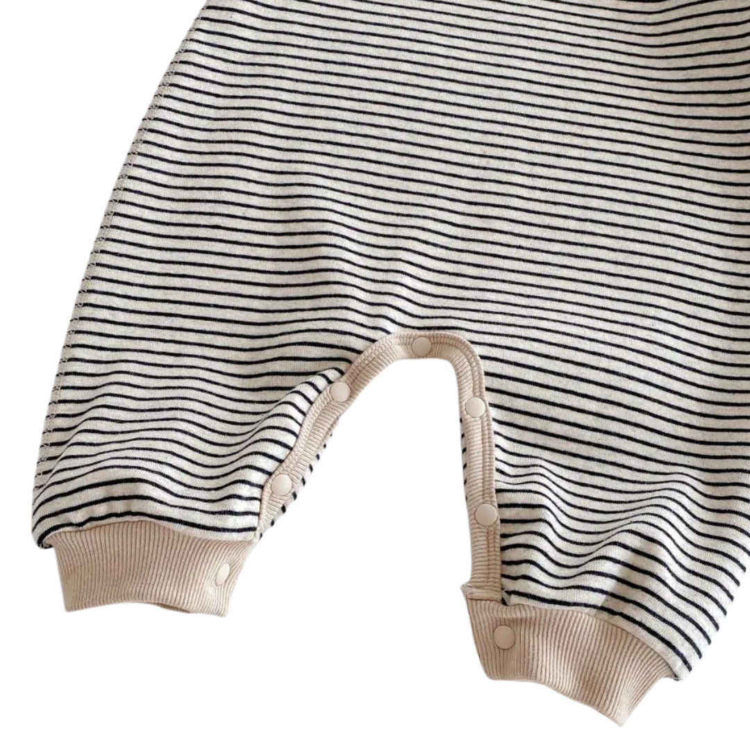 Close-up of the ribbed ankle cuffs on the Oat & Onyx neutral striped baby romper.