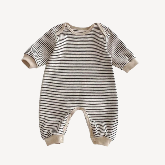 Neutral striped baby romper in Oat & Onyx featuring a cream base with distinct black stripes. Soft cotton long sleeve jumpsuit with snap buttons.