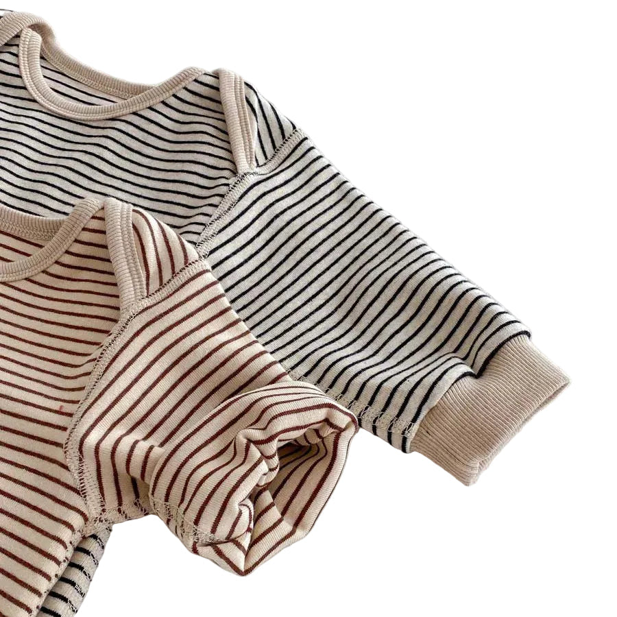 Close-up of the long sleeves and ribbed cuffs on both the Toasted Latte and Oat & Onyx striped baby jumpsuits.