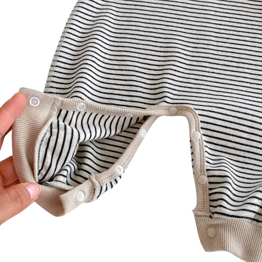 Close-up showing the inside of the Oat & Onyx baby romper with the covered snap buttons opened at the crotch for easy diaper changes.