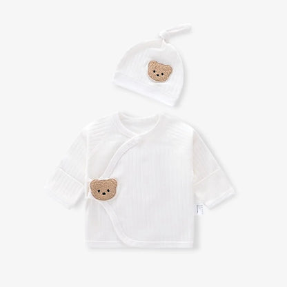 Flat lay of cream white newborn ribbed kimono top and matching knot hat featuring a textured teddy bear patch.