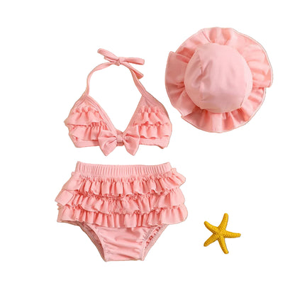 Pastel pink baby girl 3-piece swimsuit with tiered ruffle tutu shorts and matching ruffle sun hat, size 0-24 months.