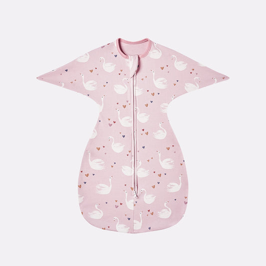 Flat lay of pink cotton swaddle transition bag with white elegant swan pattern and heart details.