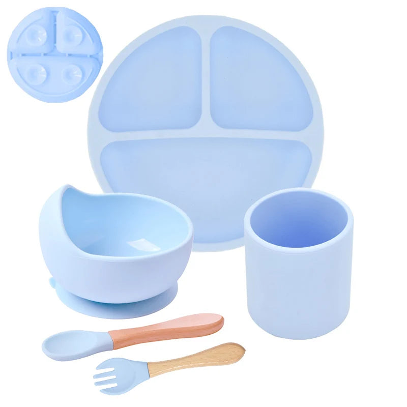 Blue silicone dining set with plate, bowl, cup, and utensils on a white background