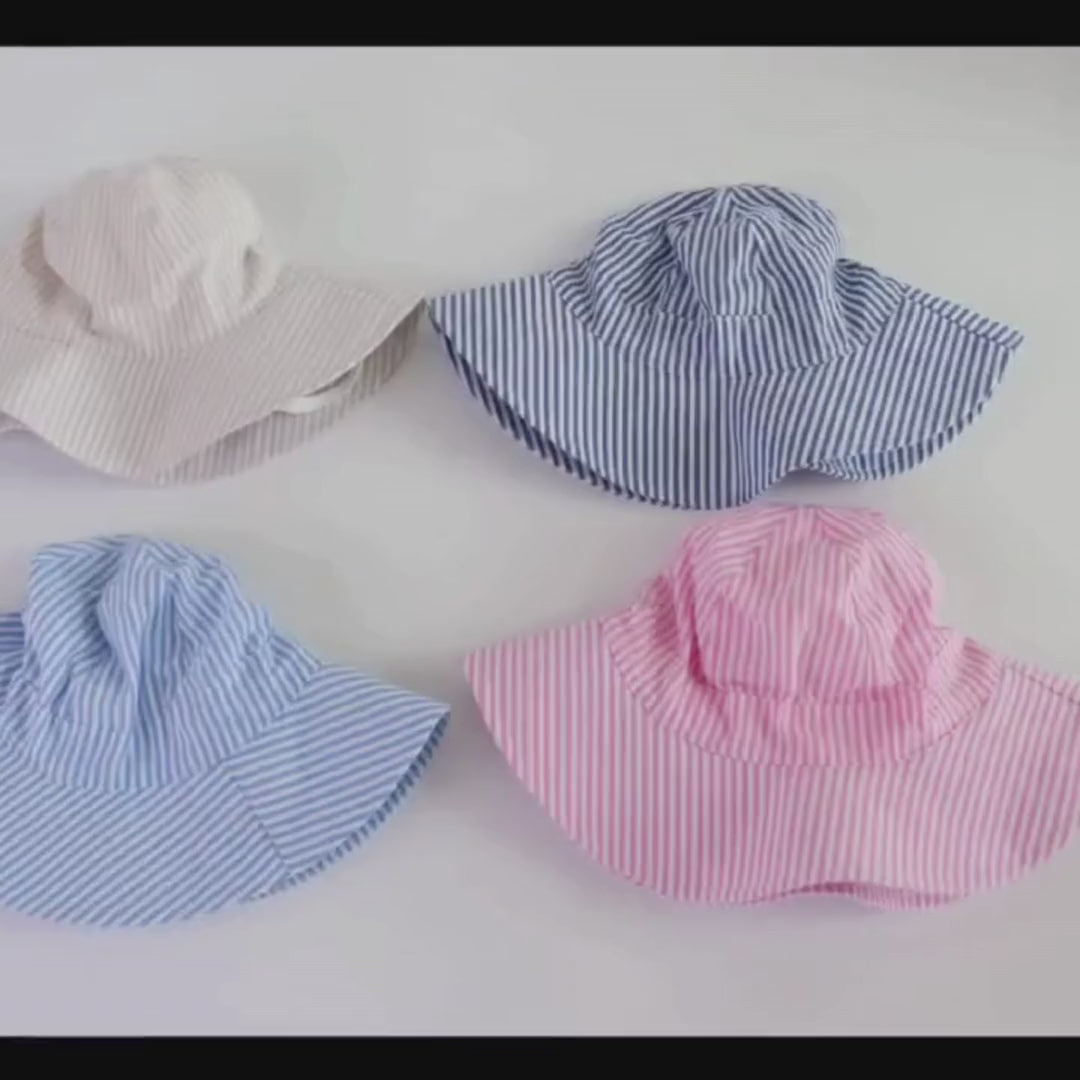 Video demonstration of the Kidsely adjustable striped cotton baby sun hat, showcasing the breathable fabric, floppy wide brim, and how to use the adjustable crown drawstring and breakaway safety chin strap for a secure fit on toddlers.