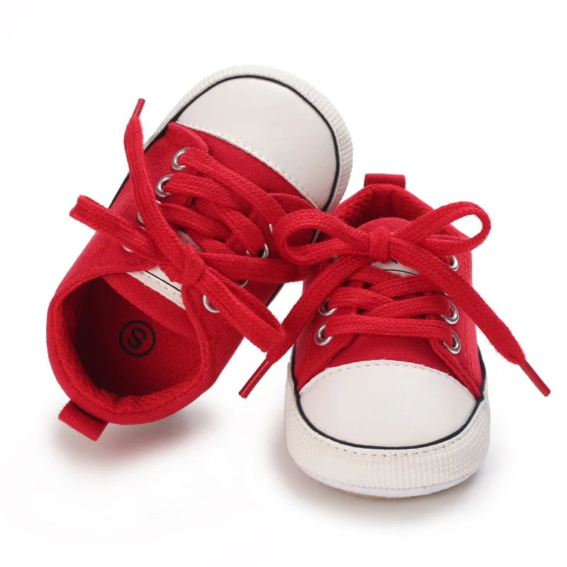 Classic red baby canvas crib shoes with white toe cap and adjustable cotton laces.
