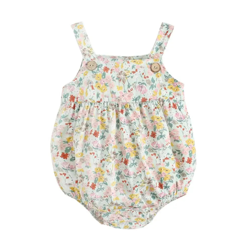 Flat lay view of a sage green floral cotton baby romper with sleeveless boho straps and vintage wood buttons.