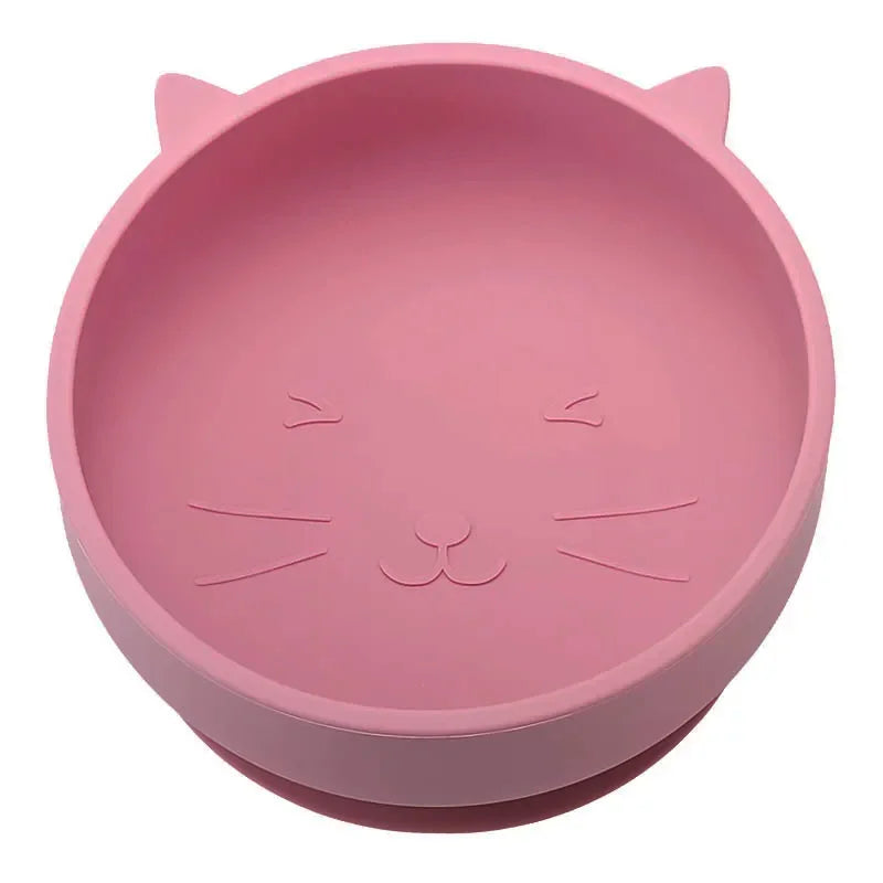 Pink silicone bowl with cat face design on a white background