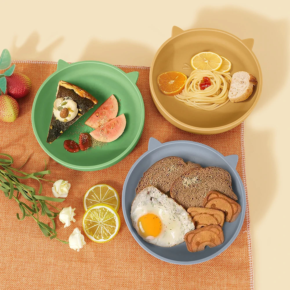 Three plates with breakfast food on a textured surface