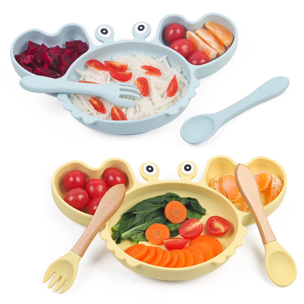 Children's plate set with compartments, utensils, and food on a white background