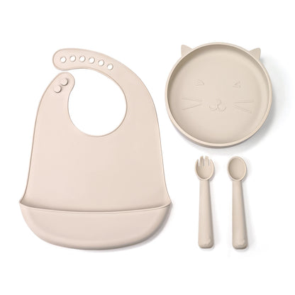Beige baby bib, plate with cat design, fork, and spoon on a white background