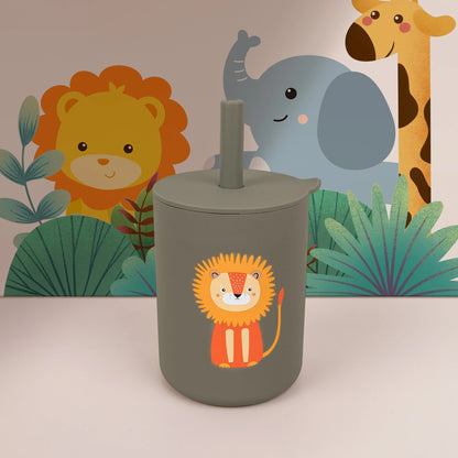 Children's tumbler with lion design in front of a jungle-themed backdrop with lion, elephant, and giraffe.