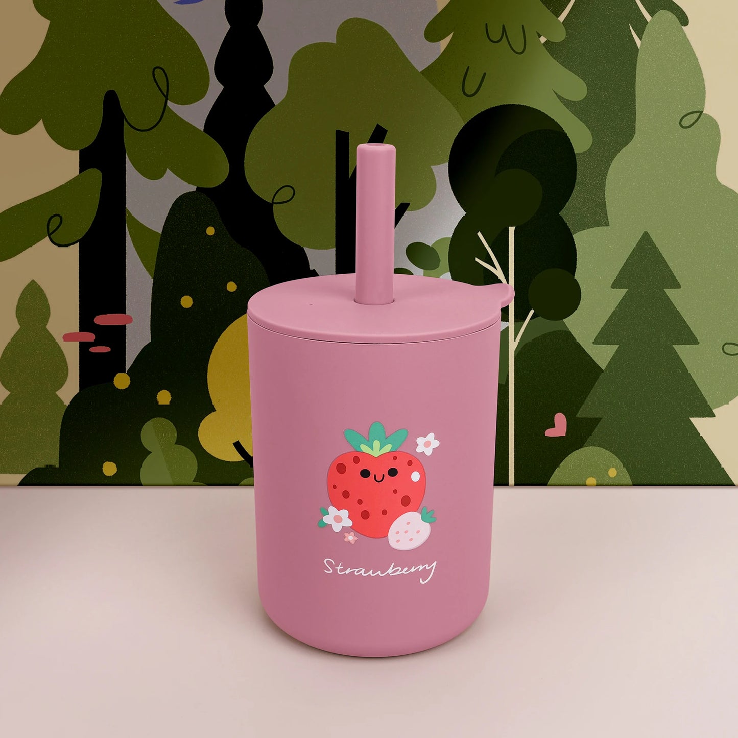 Pink tumbler with strawberry design against a forest background
