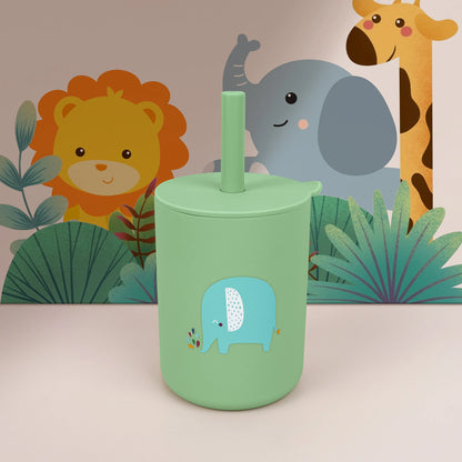 Green tumbler with a blue elephant design in front of cartoon animals on a beige background
