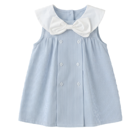 Flat lay of a toddler girl's sky blue striped sleeveless summer sailor dress featuring a large white bow, Peter Pan collar, and double-breasted buttons on a white background.