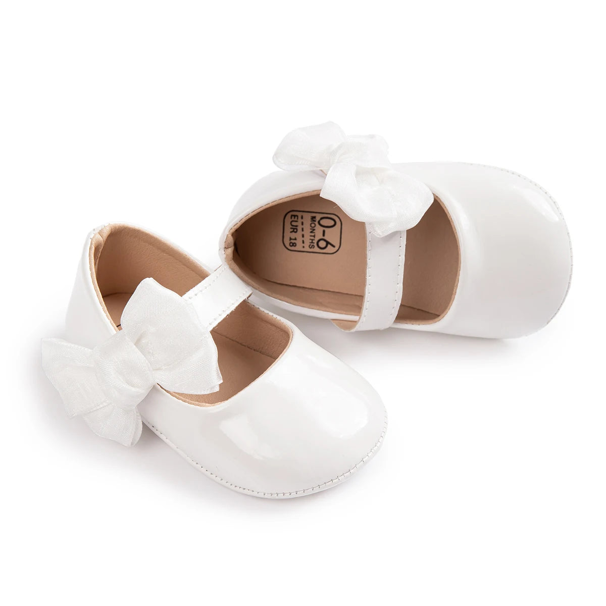 White patent PU leather baby girl Mary Jane shoes with matching white bowknot and non-slip rubber sole.