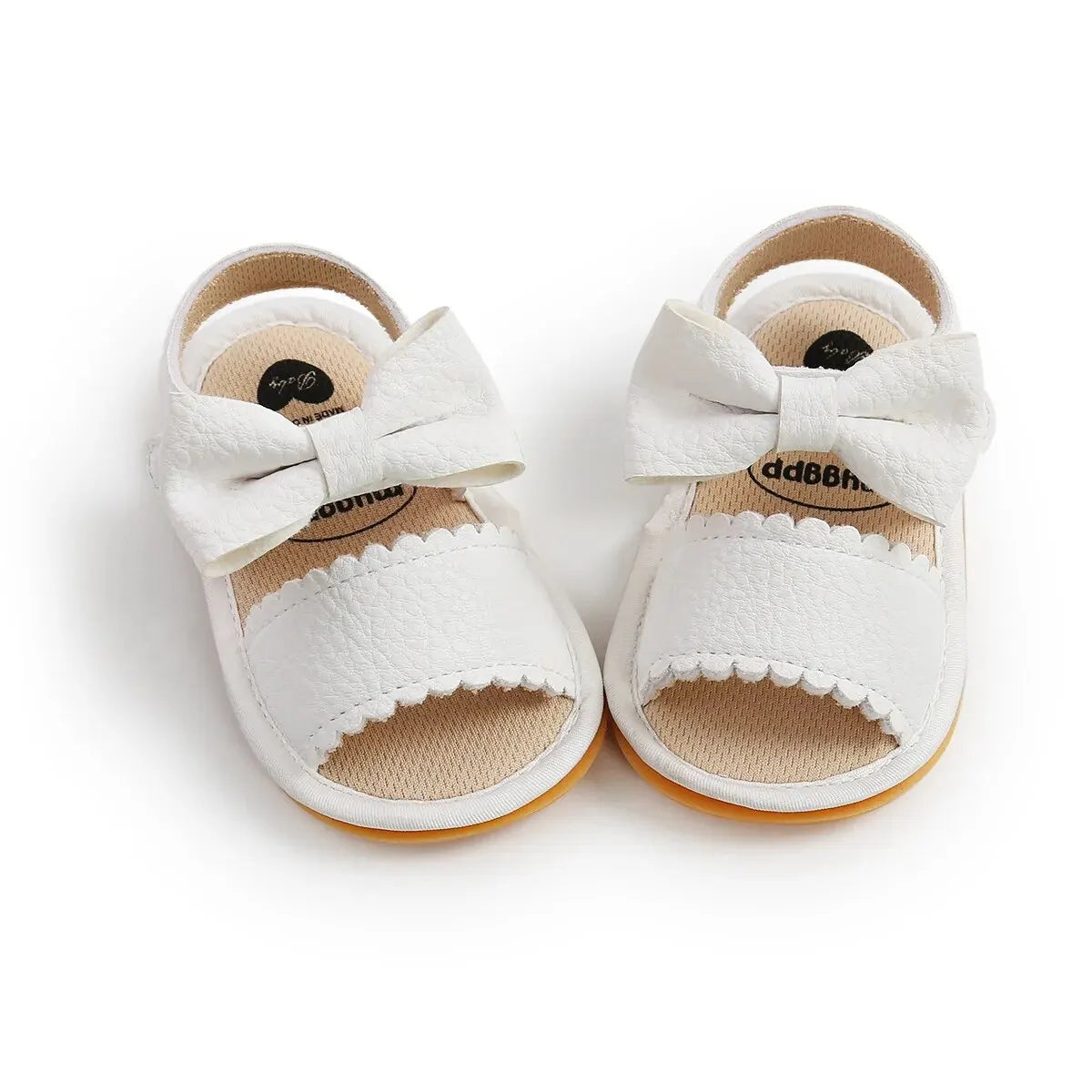 Pair of white baby girl first walker sandals with a decorative bow knot and scalloped edges, featuring a soft anti-slip rubber sole for summer walking.
